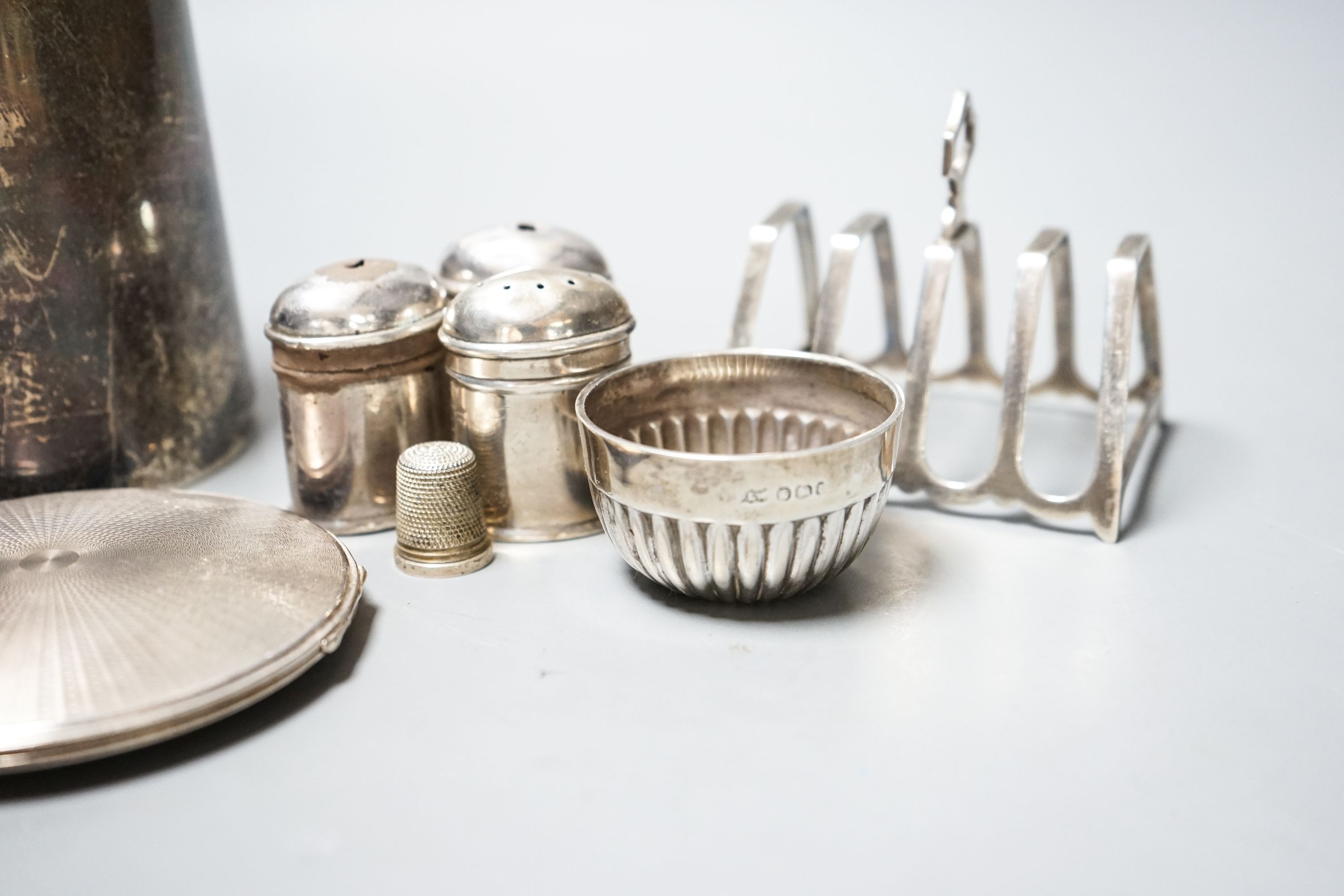 An Edwardian silver mug, by Walker & Hall, Sheffield, 1901, 12.4 cm, a silver toastrack, silver compact, four silver condiments(a.f.), a silver bowl and silver thimble